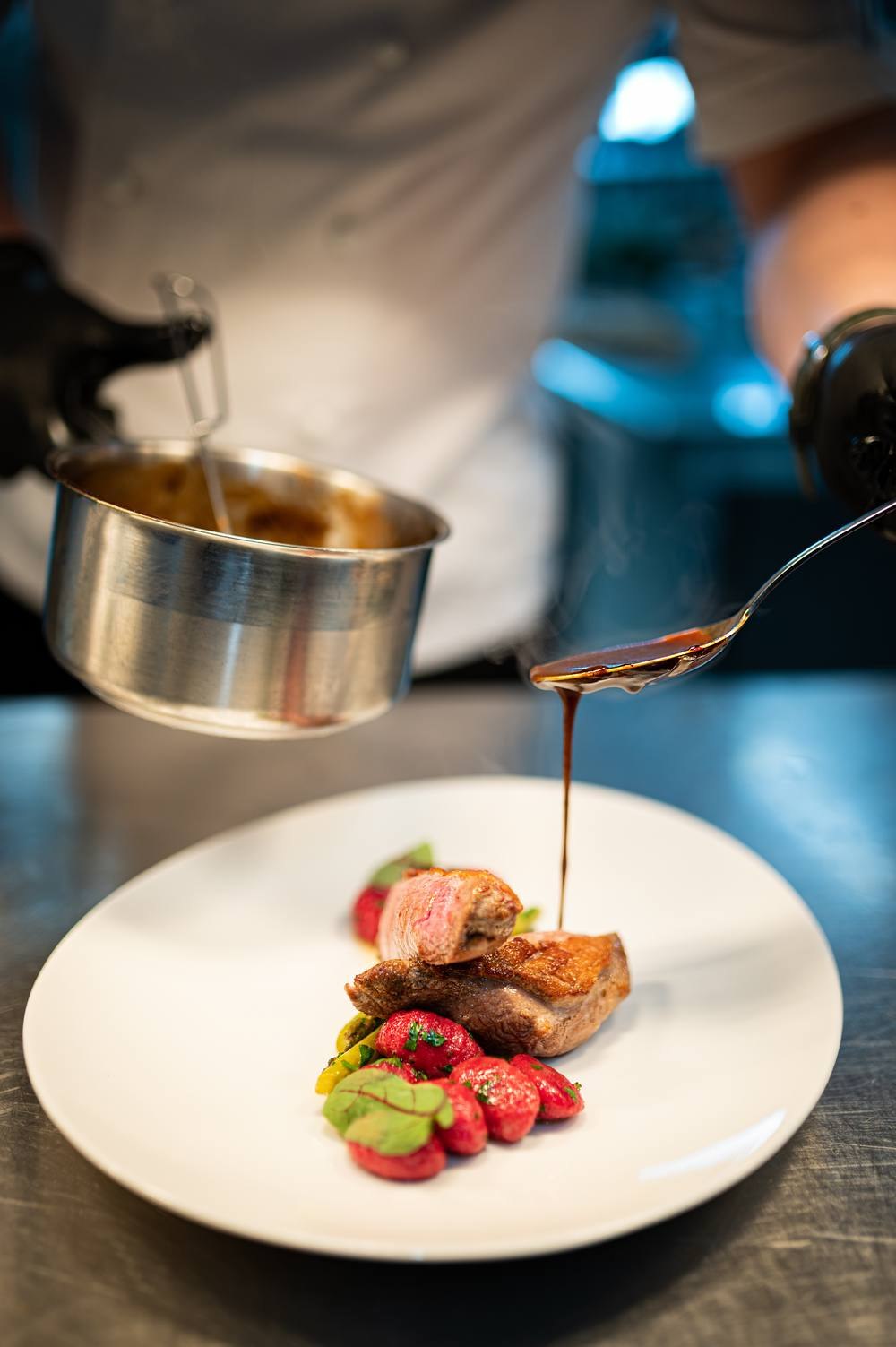 Sesja w restauracji — szef kuchni wykańcza danie