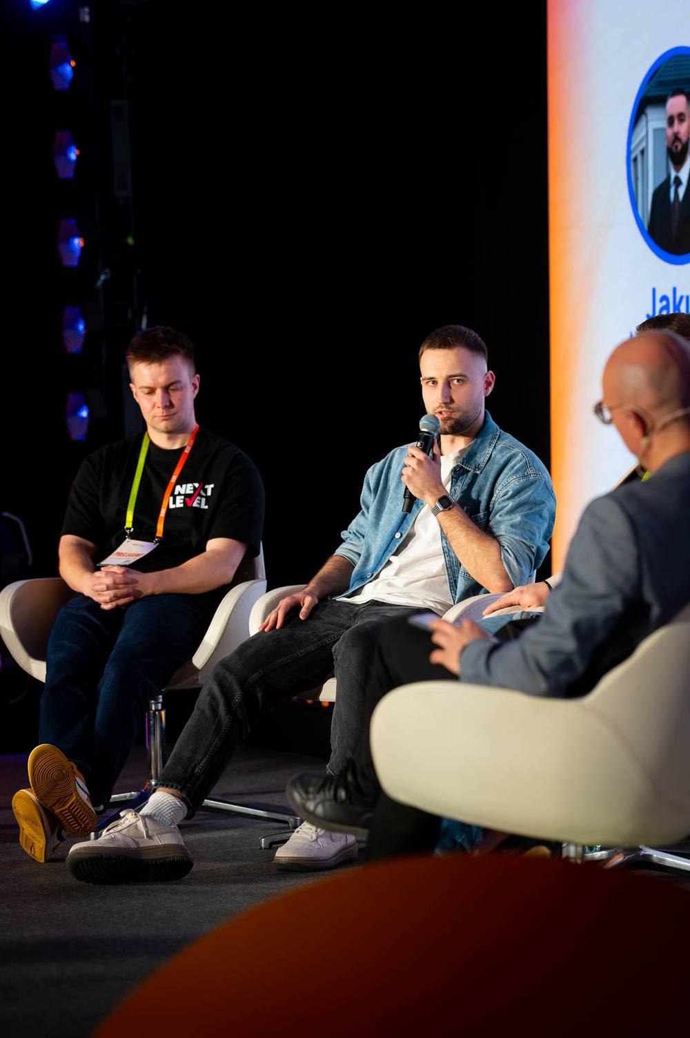 Panel dyskusyjny w fotelach na scenie